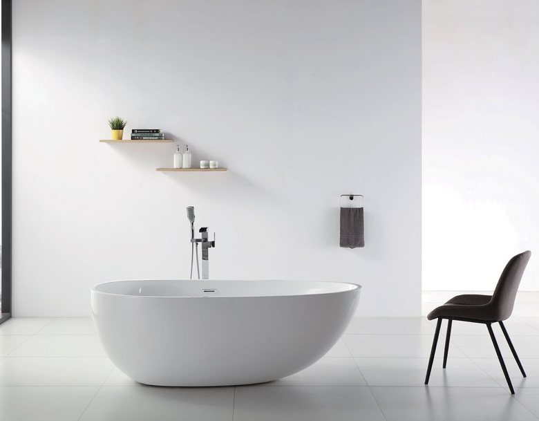 Freestanding solid surface bath with floor-mounted filler